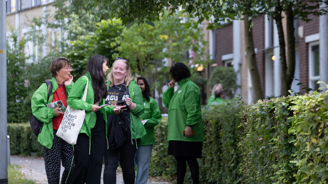 lachende vrijwilligers gaan langs de deuren