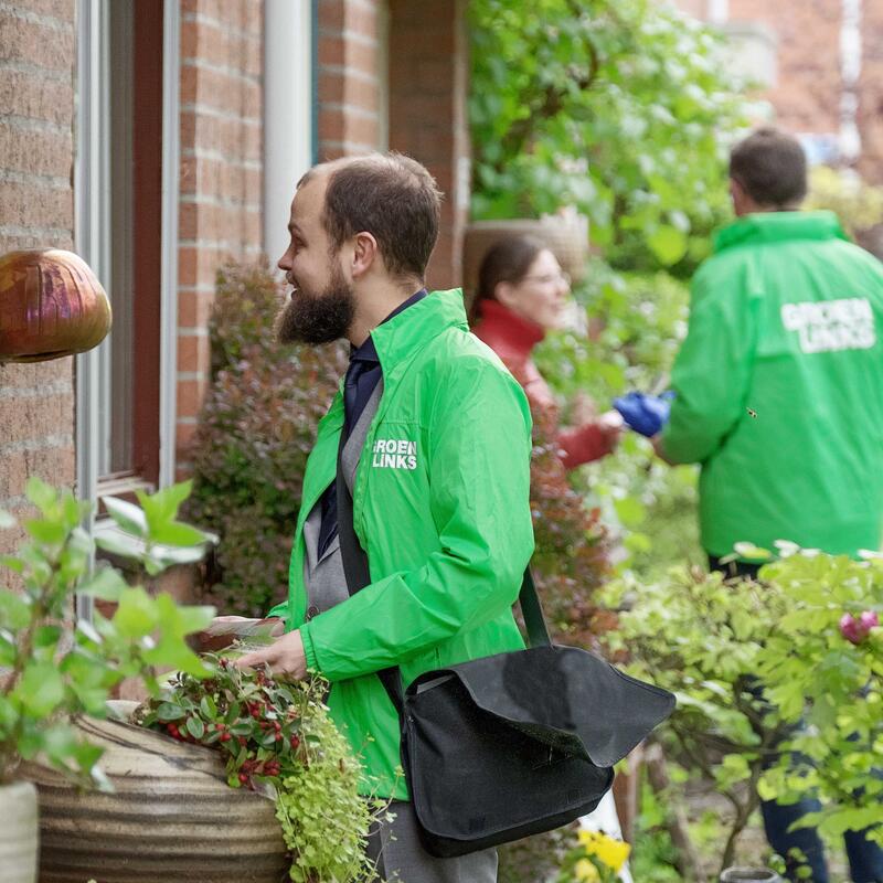 Enthousiaste vrijwilligers in een GroenLinks-jas bellen aan in de buurt om met de bewoners te spreken over wat zij willen dat de politiek voor ze doet.